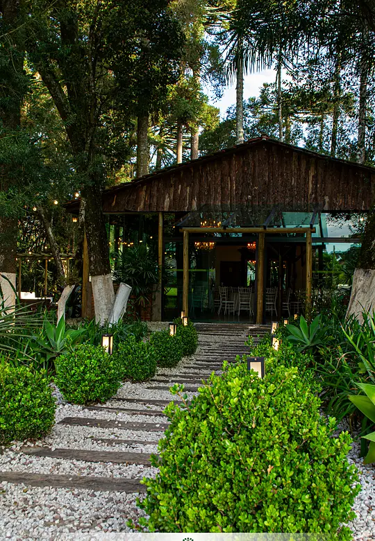 Caminho de pedra entre jardins até o salão