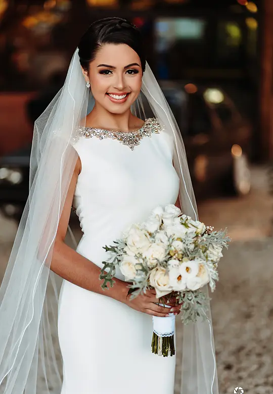 Noiva sorrindo com o buquê no jardim da chácara