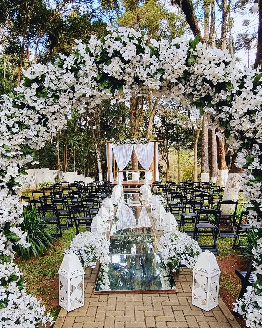 Cerimônia no bosque com arco de flores brancas