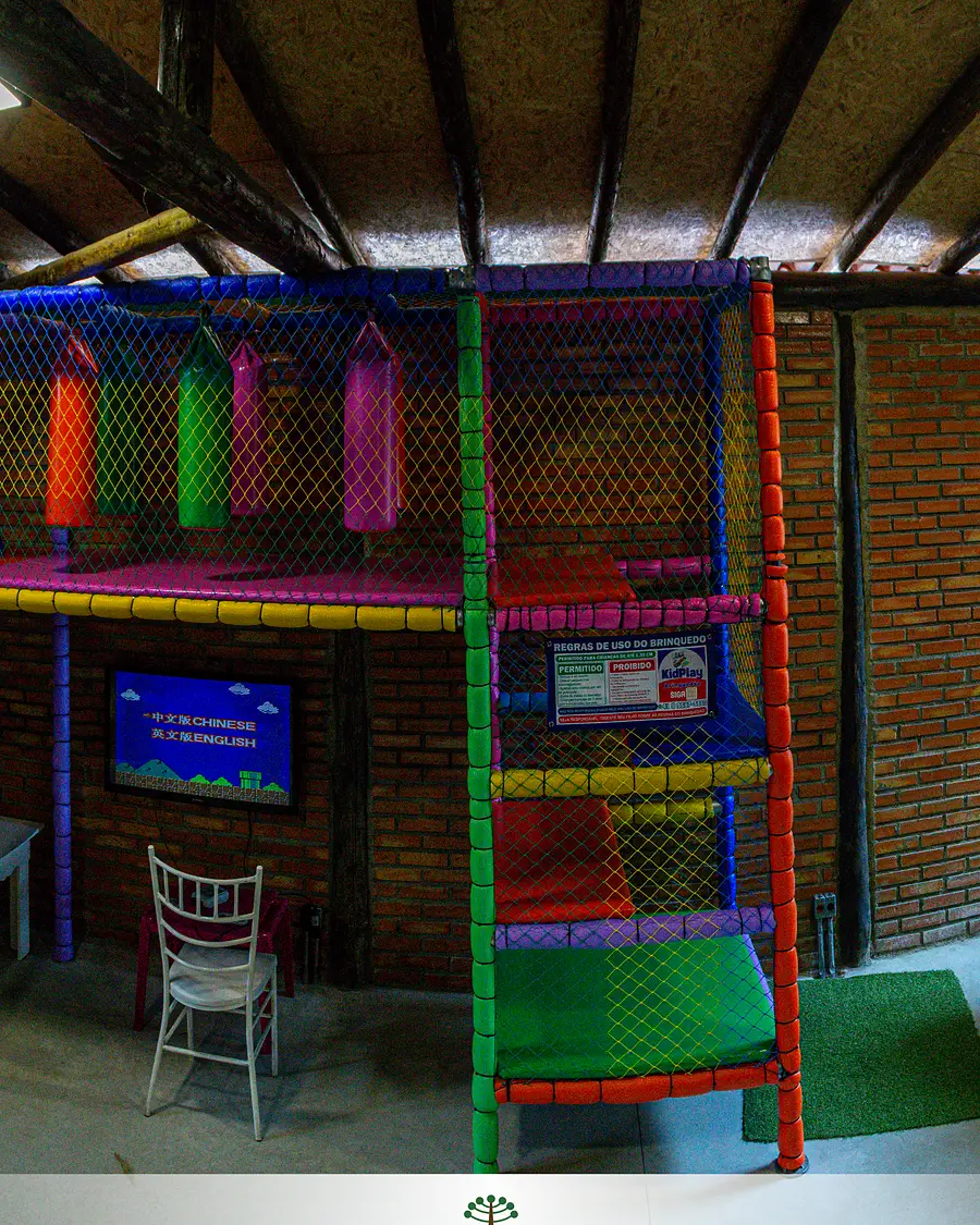 Espaço kids com brinquedão colorido, fliperamas e pebolim