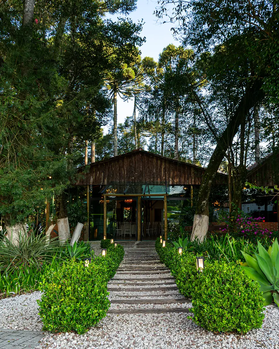 Caminho de pedra entre jardins até o salão