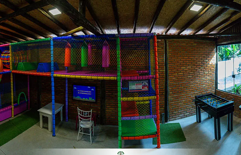 Espaço kids com brinquedão colorido, fliperamas e pebolim